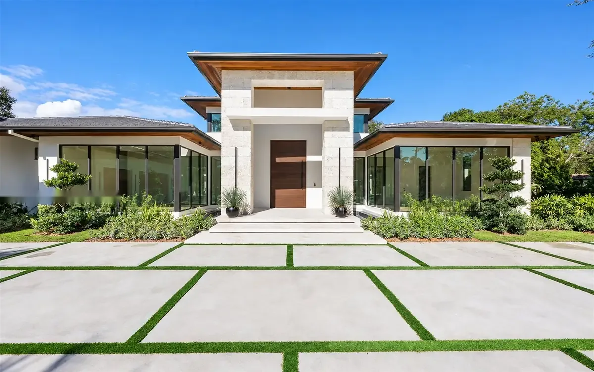 Front elevation — gated approach with mature palms