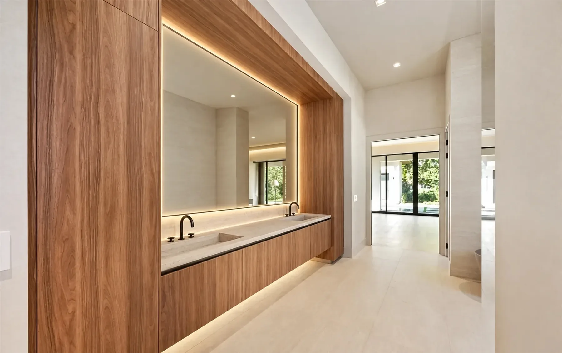 Primary bath walnut vanity niche with LED-backlit mirror