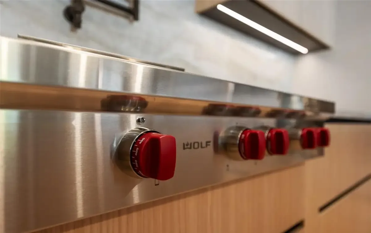 Wolf range detail — signature red knobs